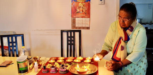 Bewoonster steekt kaarsen aan voor Divali