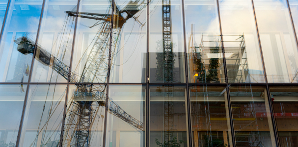 Hijskranen weerspiegelt in de ruiten