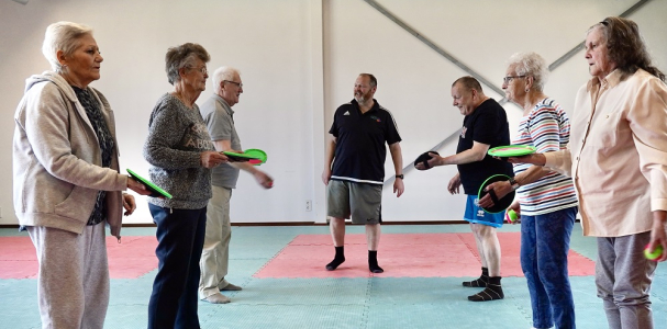 Buurtsportcoach met sportende ouderen