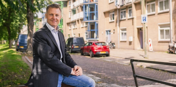 Gijsbert van Herk op hekje voor woningen