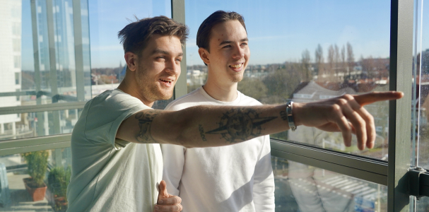 Yoshua en Rick voor het raam in hun woning aan het Maanplein