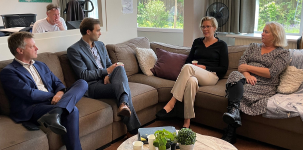 Staatssecretaris Van Ooijen en Gijsbert van Herk op de bank met twee bewoners