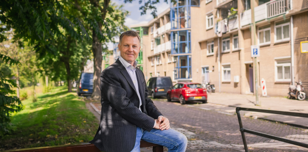 Gijsbert van Herk half zittend op hek in de wijk