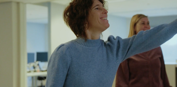 Annelies wijst iets aan aan collega