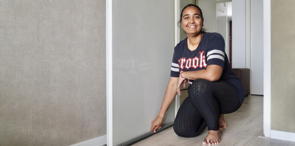 Nisha bewoner behaaglijker wonen poseert in doorgang naast de deur