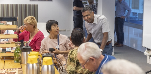 Medewerker van Staedion in gesprek met bewoners tijdens de inspiratiedag