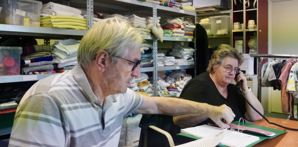  Stien aan de telefoon en Wim met een vel papier in zijn hand