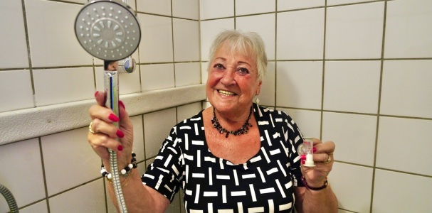 Janette met een douchekop in haar handen