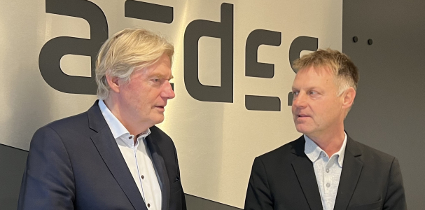 Martin van Rijn en Gijsbert van Herk voor een bord met Aedes