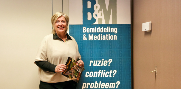 teamleider Gerda van Bemiddeling & mediation met een folder in haar hand