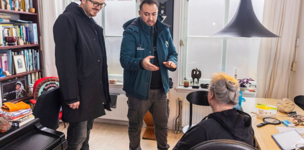 Wethouder Kapteijns en een bewoner krijgen tips voor energie besparen van enrgiefikser Achraf