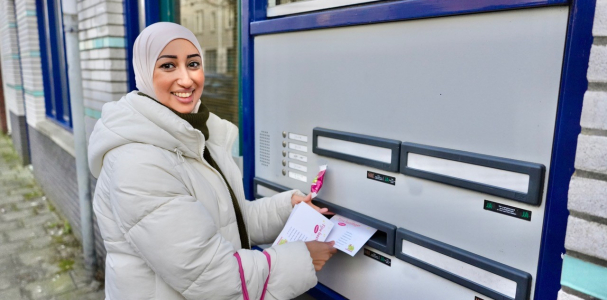 Fatima straatambassadeur doet een briefje door een brievenbus