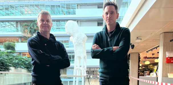 Bestuurder Gijsbert van Herk en Rijksbouwmeester Francesco Veenstra met handen over elkaar poserend in een kantoorgebouw