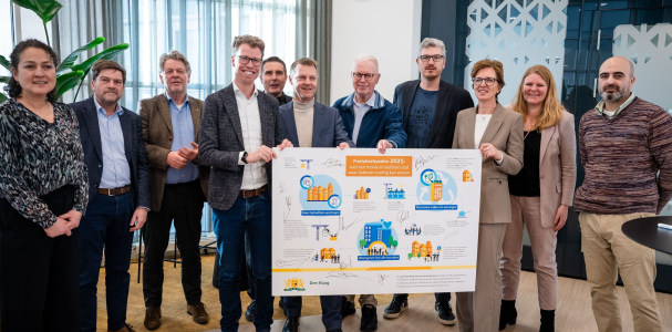 Groepsfoto van Martijn Balster en Gijsbert van Herk met een bord van de prestatieafspraken in handen met daarom heen alle woonpartners 