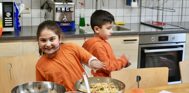 Twee vrolijke kinderen in de keuken