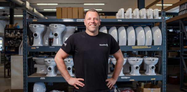 Man staat trots voor een stelling met bouwmateriaal.