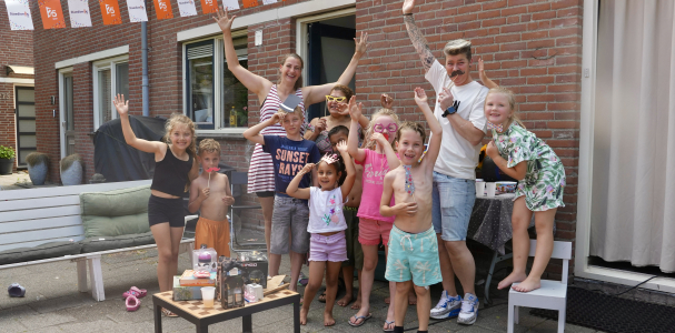 Kinderen in de Dr. J. Presserstraat die met hun handen in de lucht staan uit blijdschap