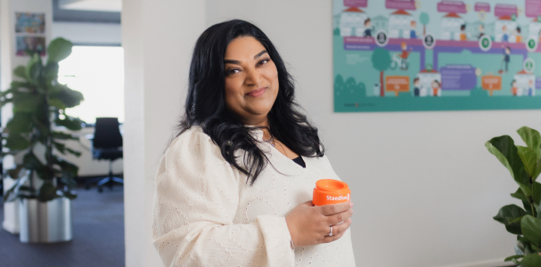 Dame geposeerd met een beker van Staedion en lacht vriendelijk