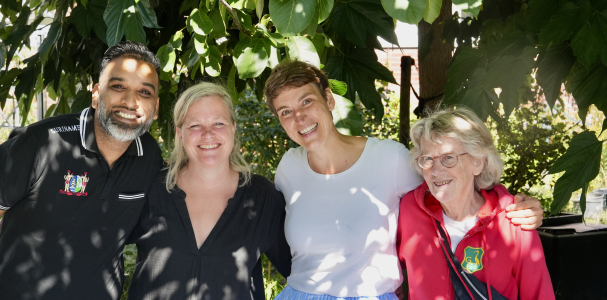 Een meneer en drie dames op een rij onder de boom