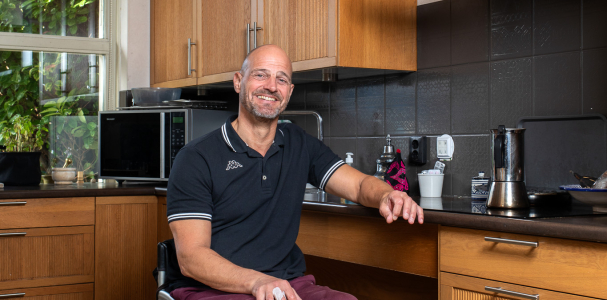 Meneer in rolstoel, in de keuken.