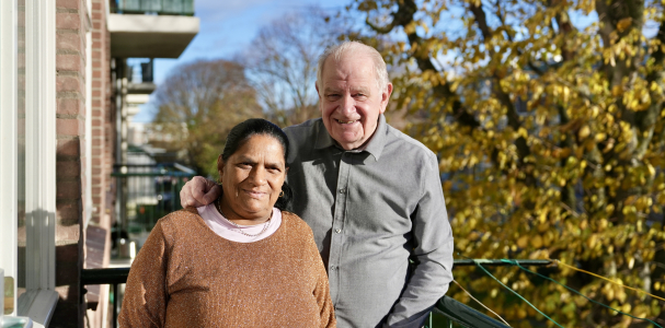 Bea en Pierre poseren op het balkon van hun woning