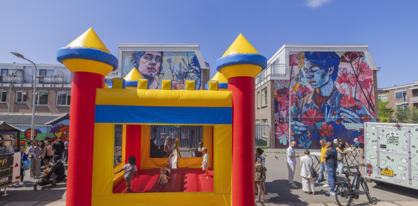 Een springkussen met daarop kinderen en eromheen volwassenen