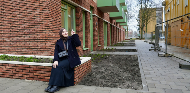 Asli bewoner van Steenzicht zit voor en wijst naar haar nieuwe huis