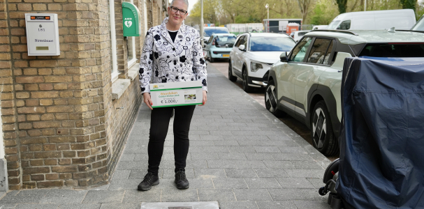 Een mevrouw met in haar handen een waardebon voor de Gulden Klinker