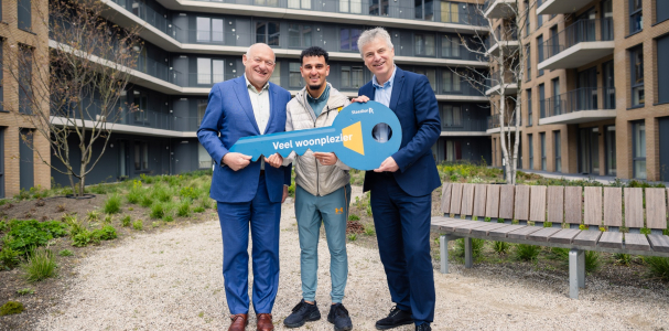 Bewoner Ibrahim ontvangt de symbolische sleutel van zijn nieuwe woning