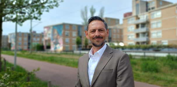 Kay Schellen met op de achtergrond woningen van Staedion aan de Laakweg