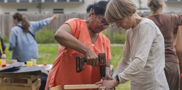 Twee dames maken samen een plantenbak voor aan het balkon