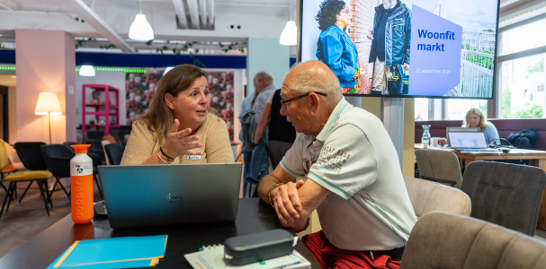Doorstroommakelaar Evelien in gesprek met een bezoeker van de Woonfitmark