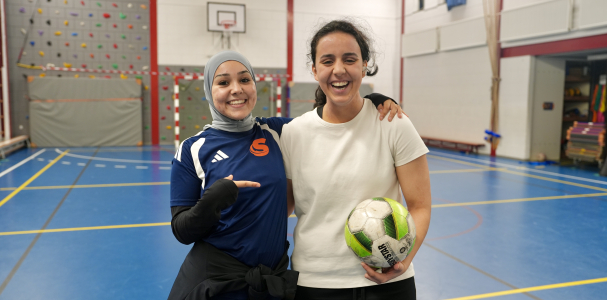 Twee meisjes in een sporthal met een bal in hun hand