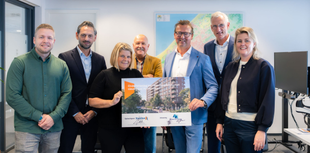 Groep personen rond het bord dat ondertekend is