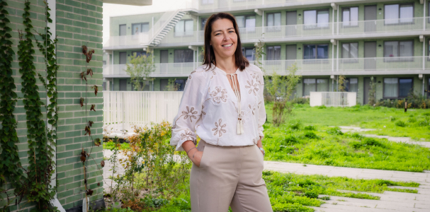 Monique in de tuin met op de achtergrond de woningen van Steenzicht