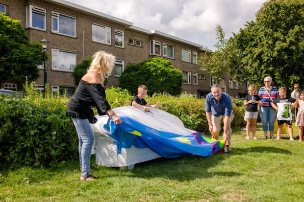 Bewoners blazen een luchtkussen op voor het vermaak van de kinderen