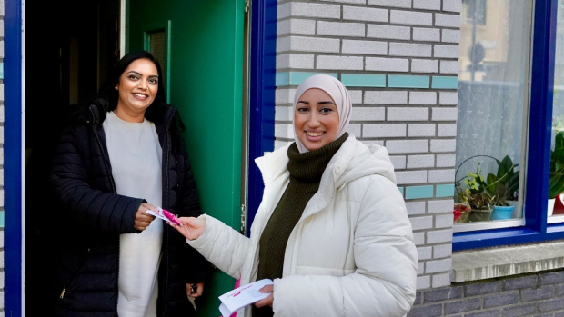 Fatima geeft een kaartje aan buurtvrouw in de Retiefstraat