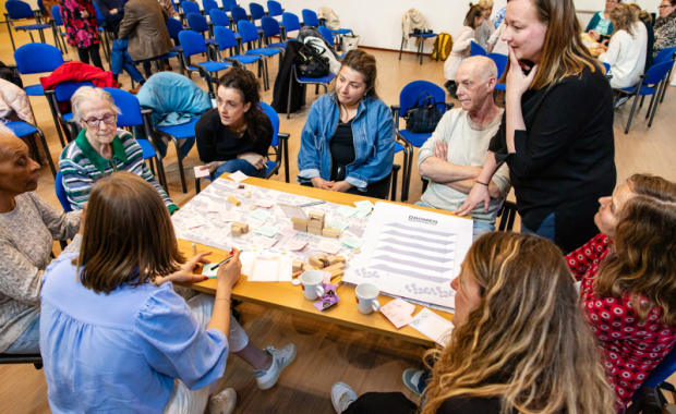 Bewoners, professionals in zorg en welzijn, en ontwerpers in een creatieve sessie rond een tafel.