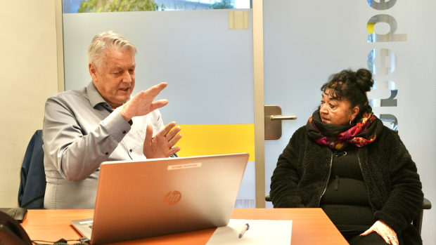 Walter van Sociaal Raadslieden achter de laptop met een bezoeker in gesprek