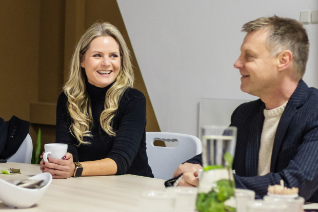 Esther en Gijsbert in gesprek aan tafel met een kop koffie