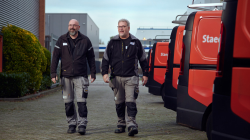 Twee vakmannen lopen naar Staedion bus