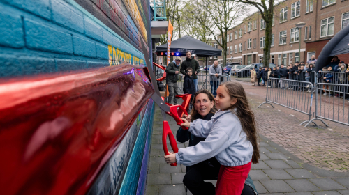 Meisje knipt samen met Marieke Stam het lint door