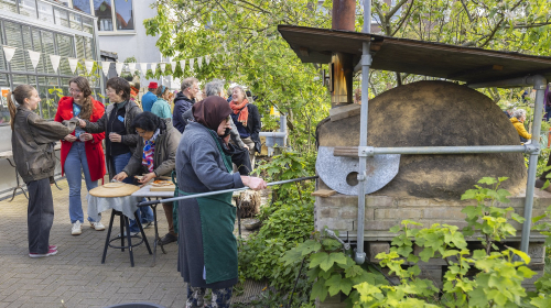 Pizza bakken in de oven tijdens 10 jaar Spinozahof