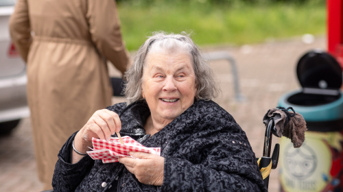 Een bewoner eet een patatje tijdens de onthulling