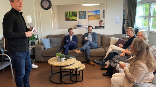  Francesco Veenstra, Maarten van Ooijen en Gijsbert van Herk in een woonkamer in gesprek met de bewoners