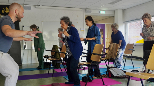 Man geeft stoelyoga voor ouderen