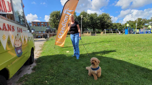 Bewoner met een hondje aan de lijn bij de ijsbus 