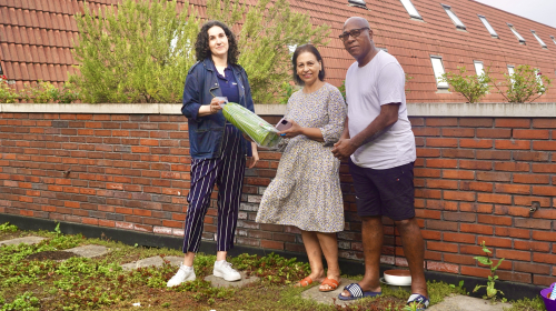 Uitreiken tuinslang aan twee bewoners