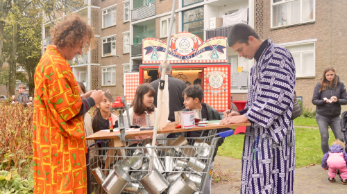 De betovering kunstenaren aan de slag met daarachter kinderen