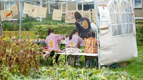 De betovering binnentuin, kinderen aan het werk onder een tent